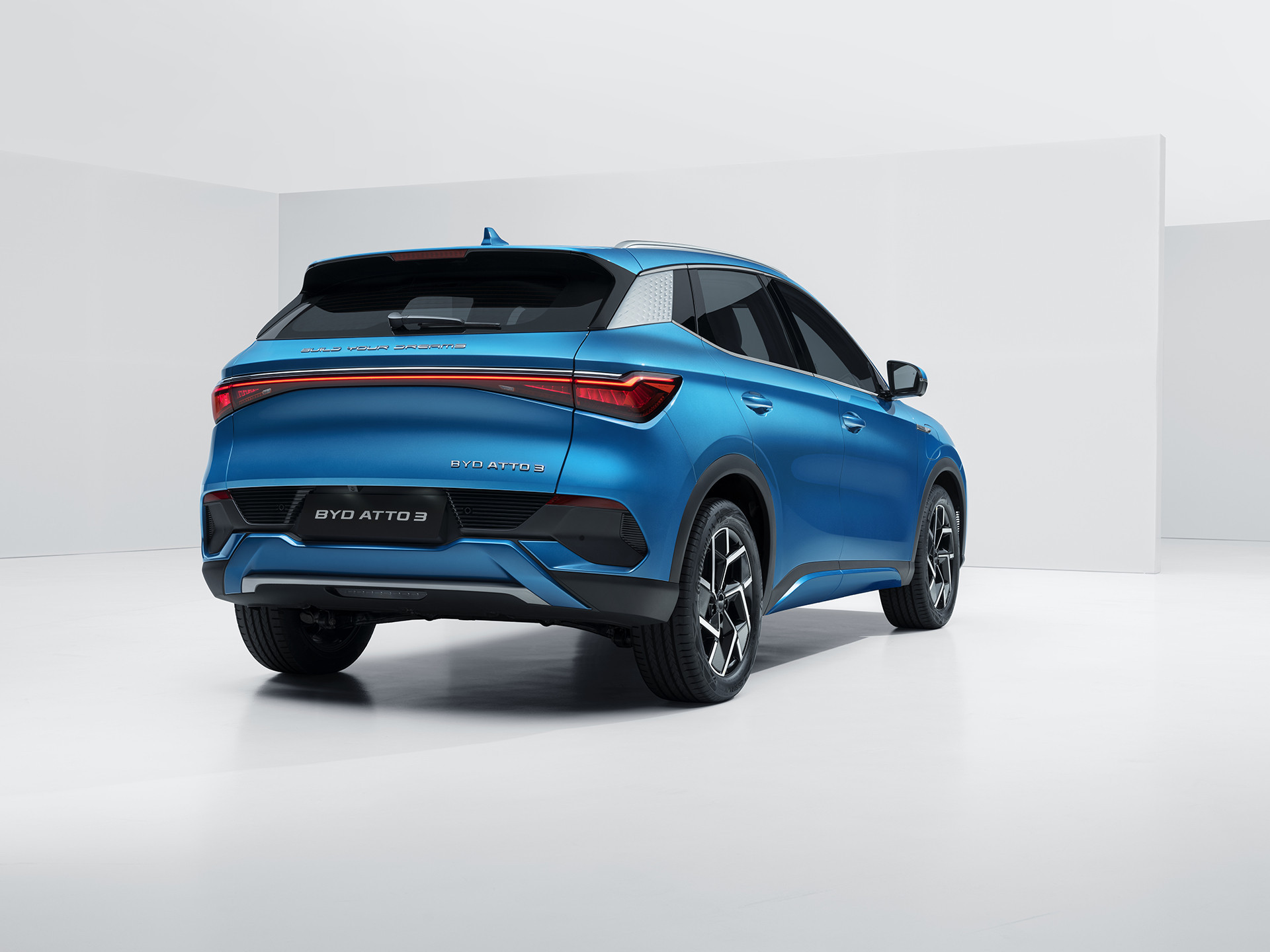 A photograph of a Surfing Blue BYD Atto 3 from the rear three quarter